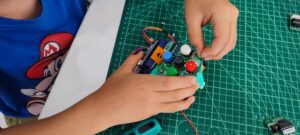 Manos de una niña construyendo un robot Escornabot